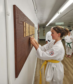 Student placing rank on Nafudakake board.